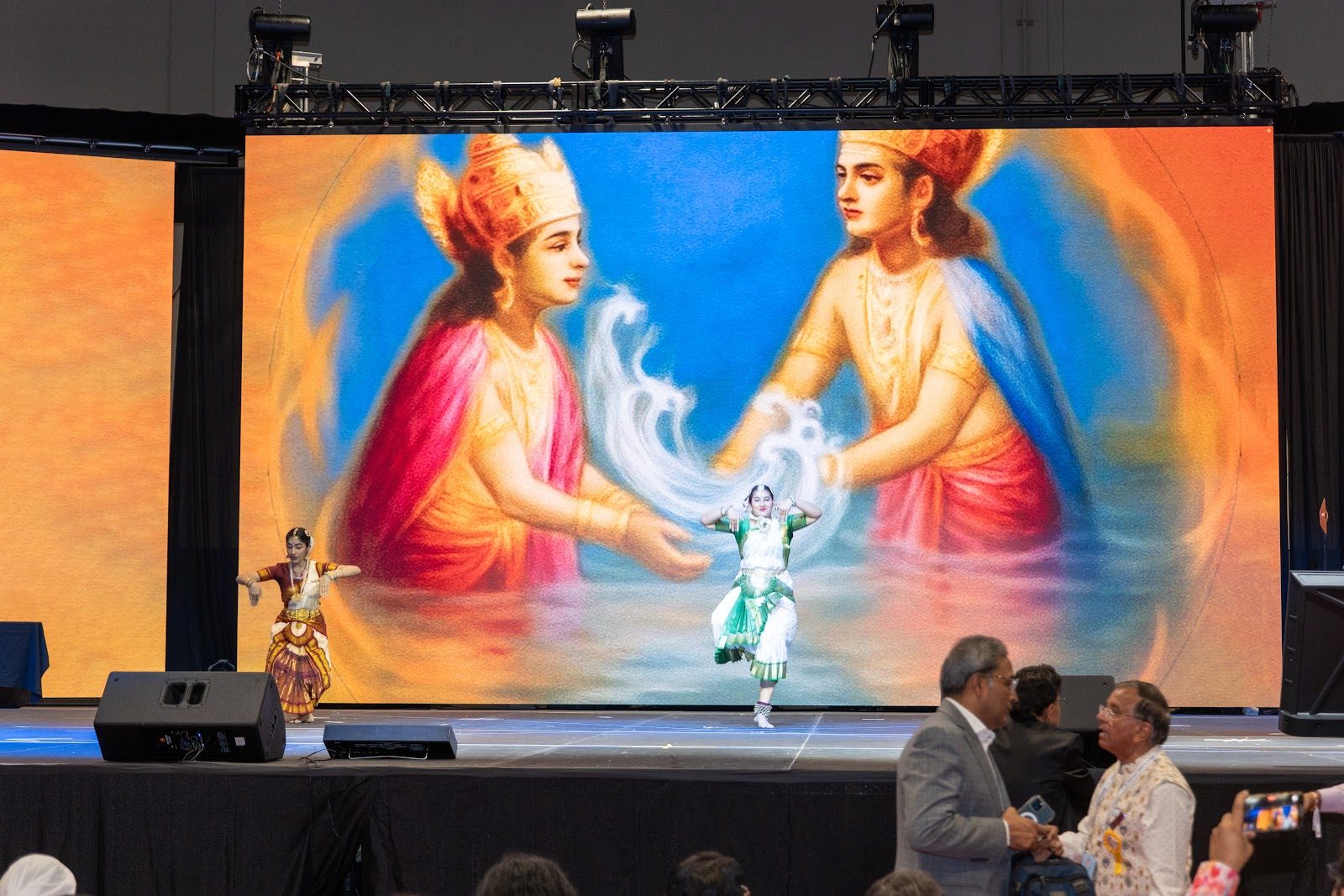 JAINA Convention 2025 — classical dance before a giant mural